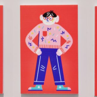Czerwony magnes. Magnes z ilustracją wisi na okapie w kuchni. Na ilustracji na czerwonym tle Franek – bohater wystawy. Ubrany w różowy sweter i niebieskie spodnie. Stoi z założonymi na biodra rękami.